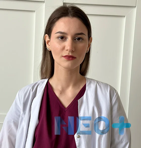 женщина врач в белом халате смотрит на зрителя